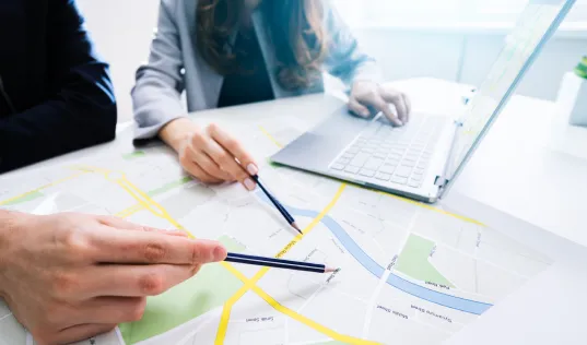 People pointing with pencils at a map