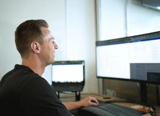 Side profile of support rep on his computer.
